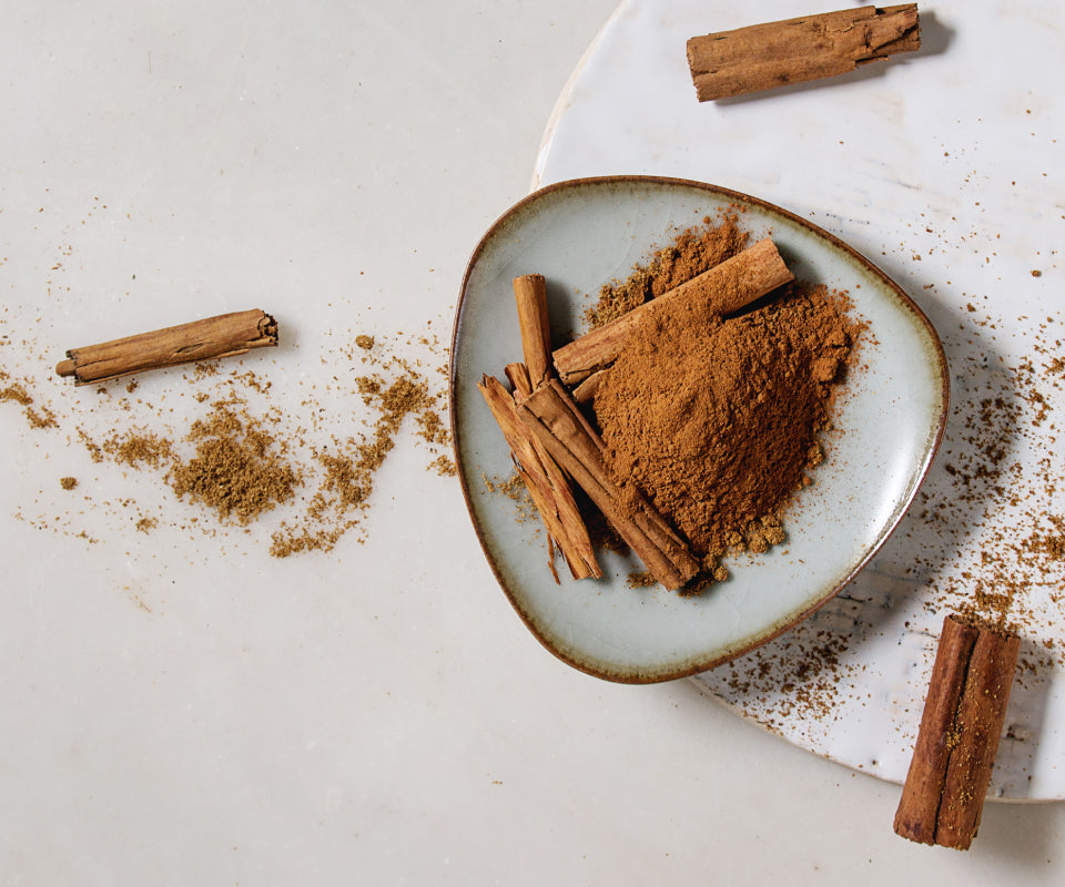 Cinnamon sticks and ground cinnamon on a plate, an ingredient in Krocus & Co. Cinnamon & Clove tea