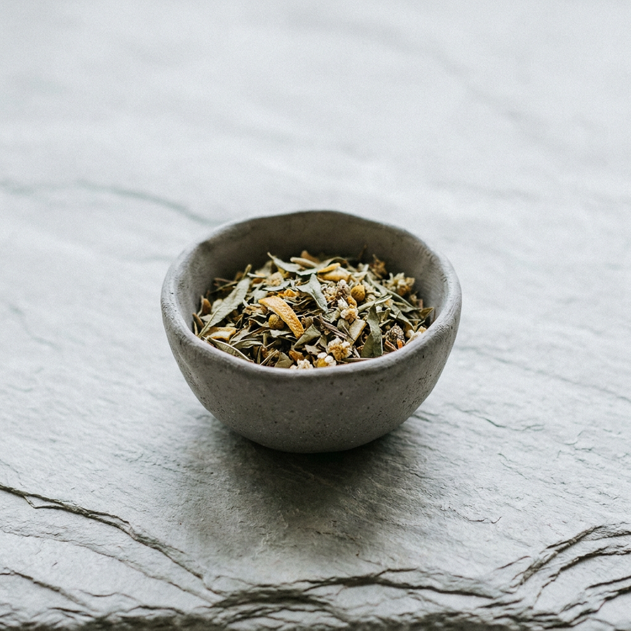 Stone bowl of dried herbal tea blend, the loose blend for Krocus & Co. Sage & Lemon Verbena tea